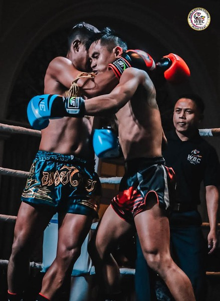 Two fighters clinch in the ring